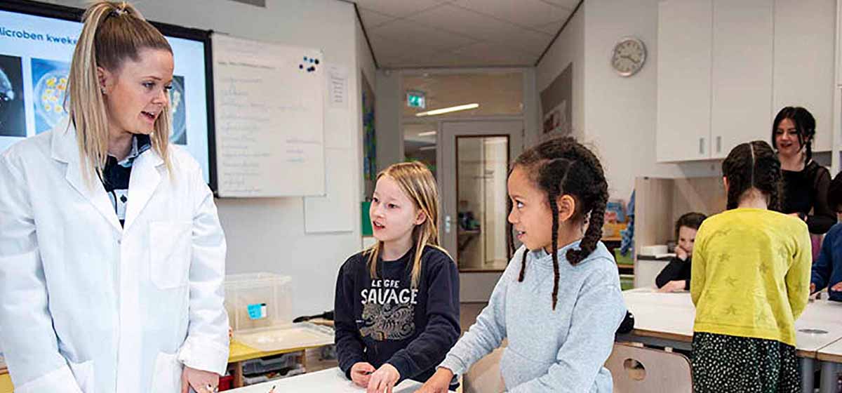 Female employee of Winclove teaches children during Artis Micropia.