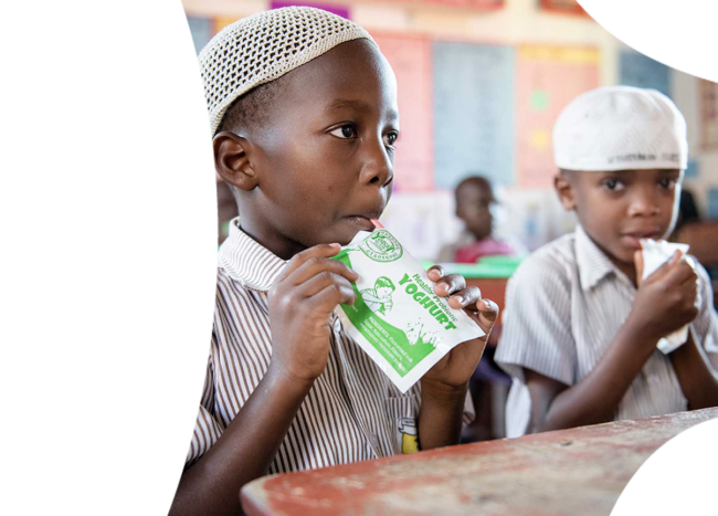 Two small African boys enjoying probiotic yohghurt